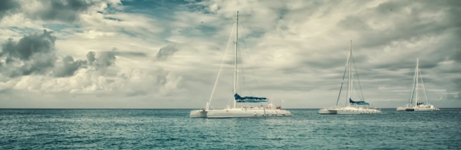 three sailboats on the water