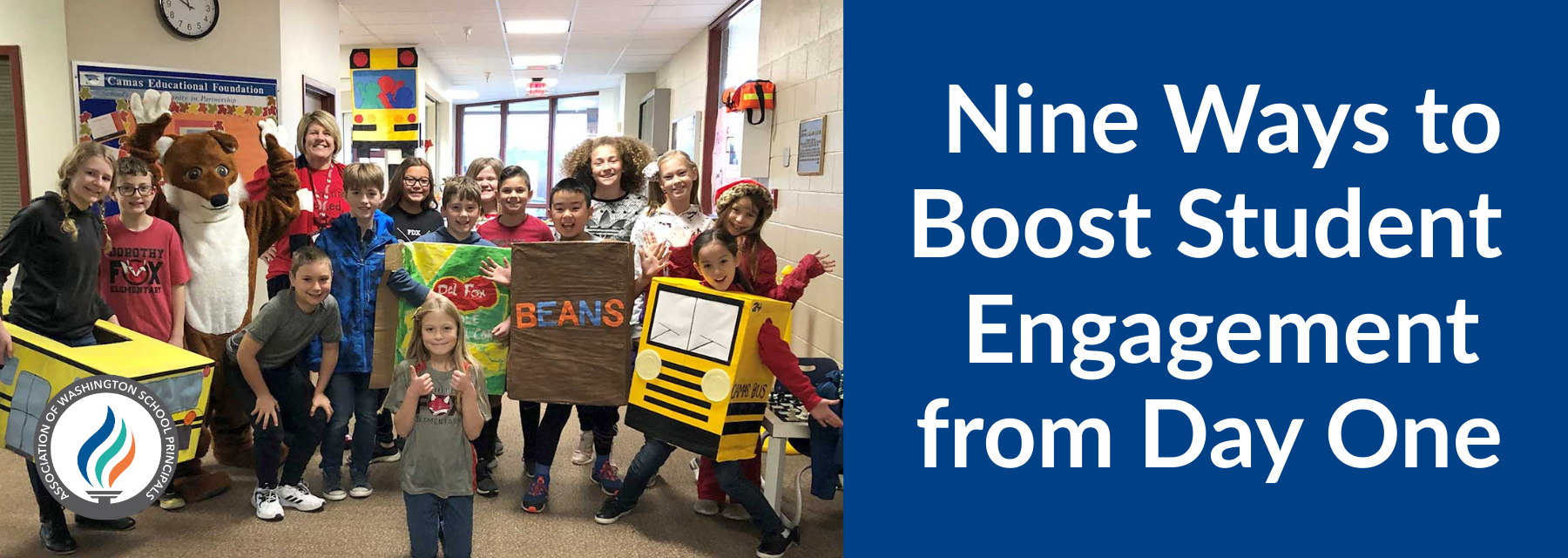 Group of smiling students and teacher in costumes, including buses, beans, and a fox mascot, in a school hallway.