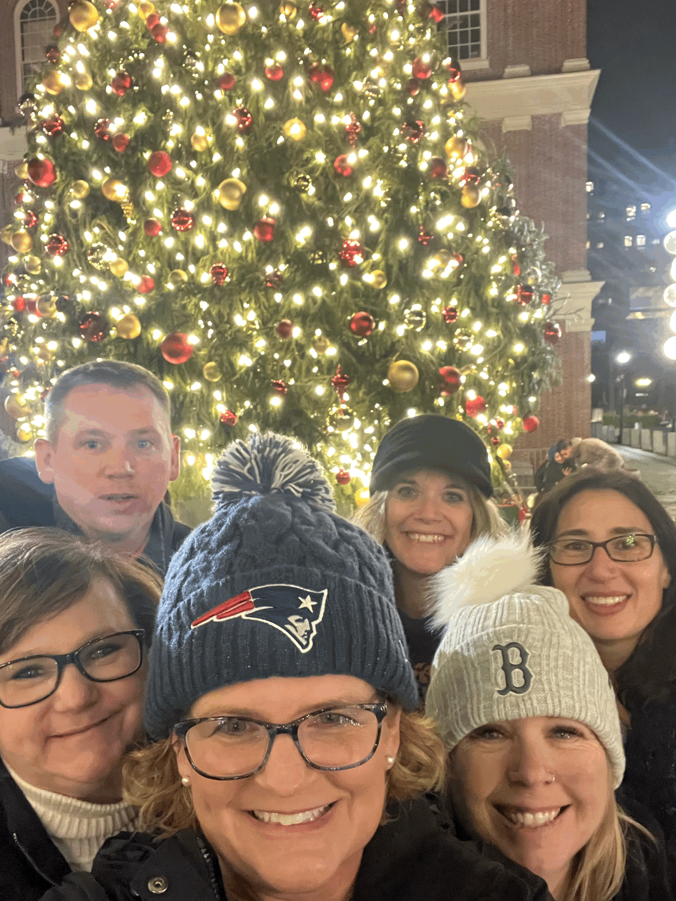 a group of five women and one man from the Kelso School District in front of a Christmas tree