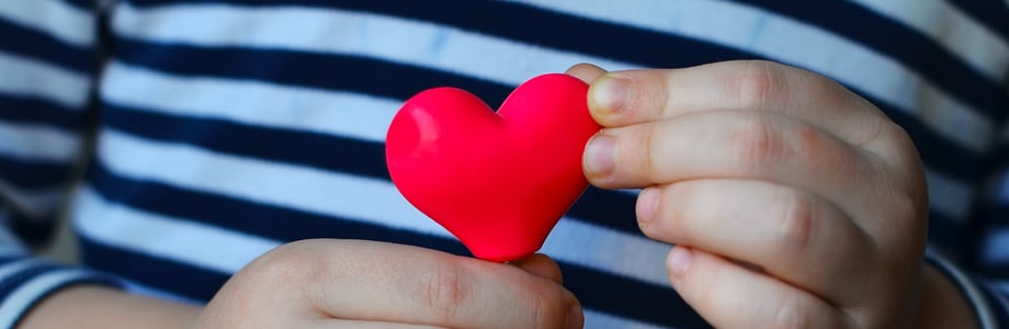 child's hands holding a small heart
