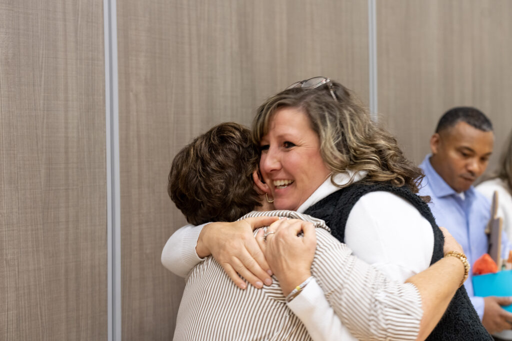 Kim Doughty smiling and hugging another woman. 