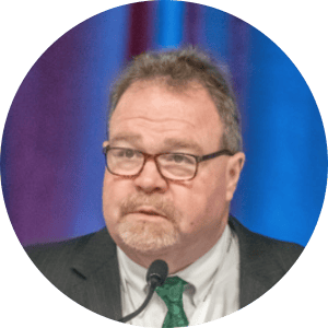 dave riddle at a podium with glasses