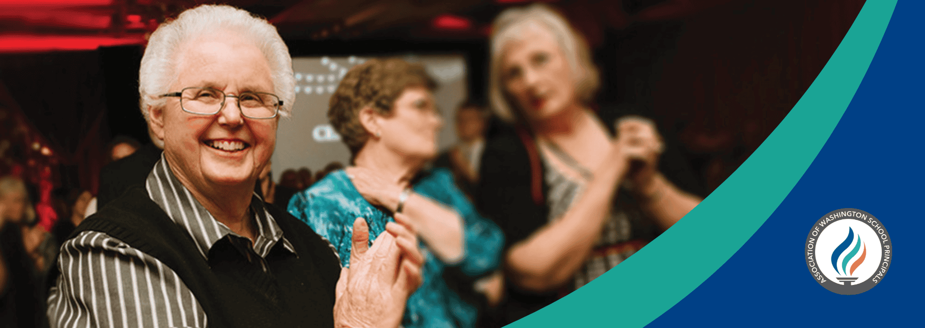 Smiling elderly woman claps at an event with others in the background; AWSP logo at bottom right.