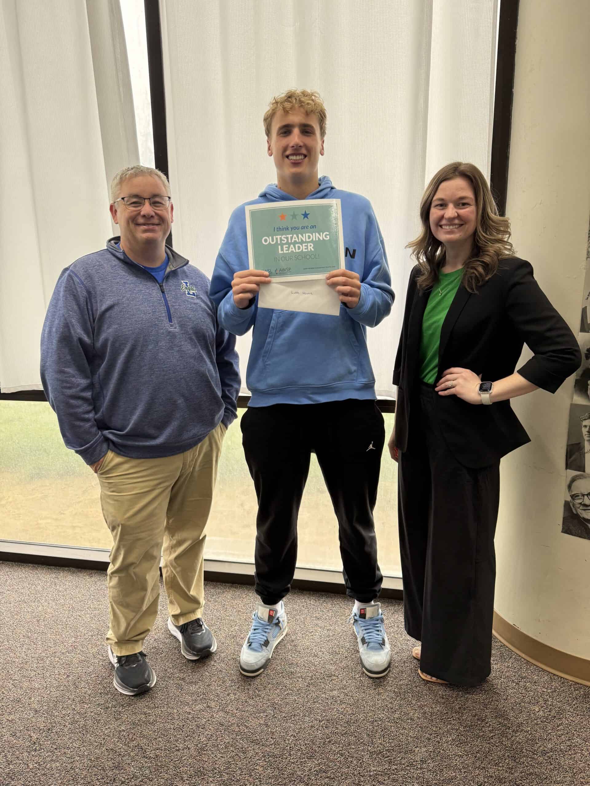 Student in blue hoodie holding 